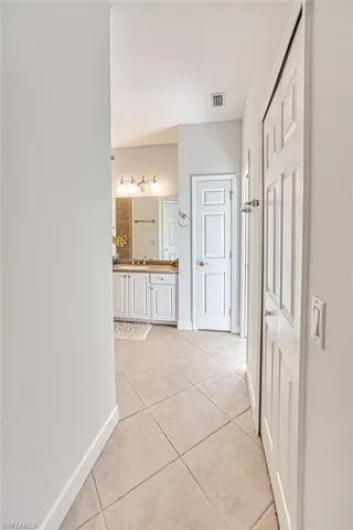 Hallway with sink and light tile patterned flooring