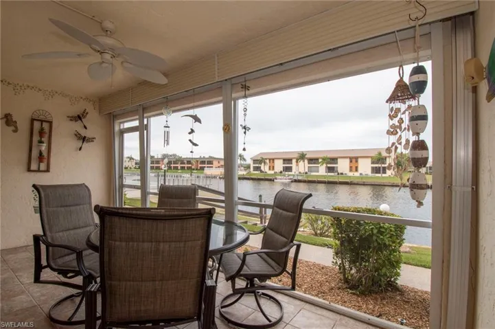 Sunroom / solarium featuring a water view and a residential view