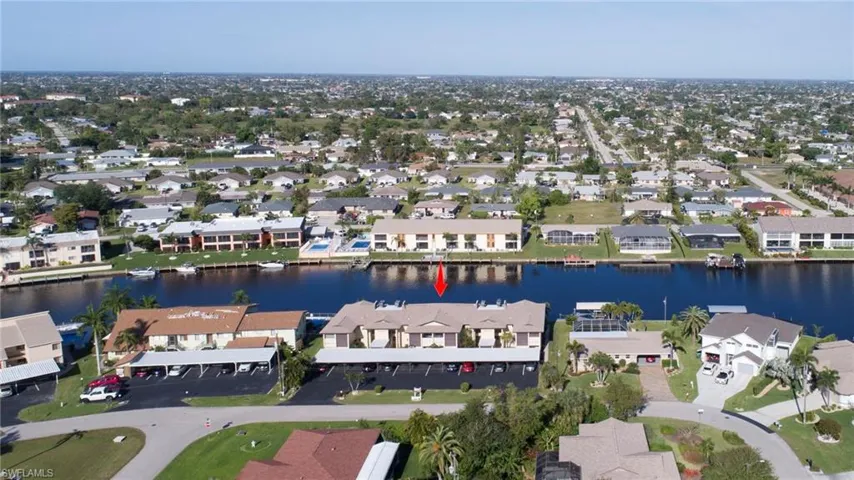 Aerial view of property's location with a large body of water and nearby suburban area