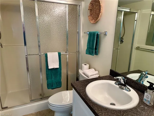 The step-in shower features sliding glass doors.