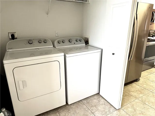 Laundry area with washer and dryer is being bi-fold doors.