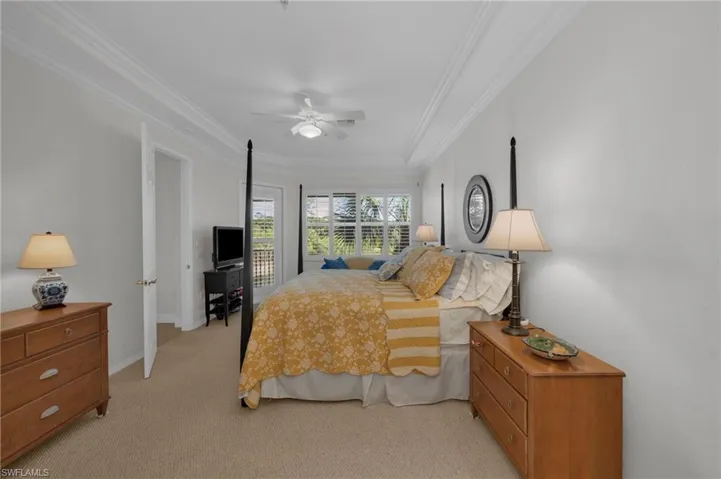 Bedroom with light carpet, a ceiling fan, and ornamental molding