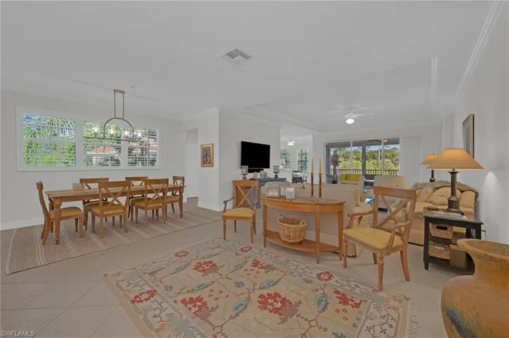 Living area featuring crown molding and a chandelier