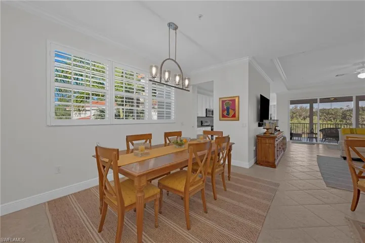Dining space featuring crown molding, a chandelier, and ceiling fan