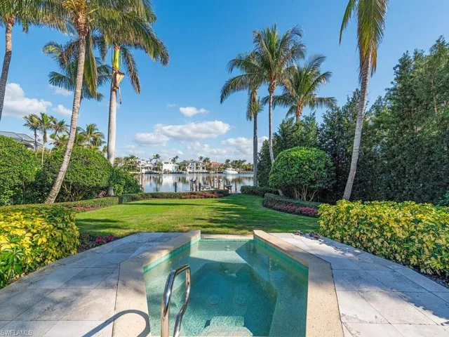 View of pool featuring an in ground hot tub, a water view, and a yard