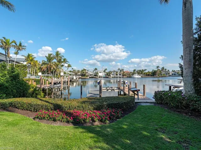 View of dock with a water view and a lawn