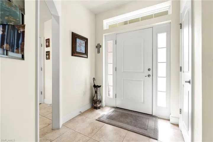 Foyer featuring light tile patterned floors and arched walkways