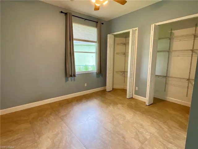 Unfurnished bedroom featuring two closets and ceiling fan