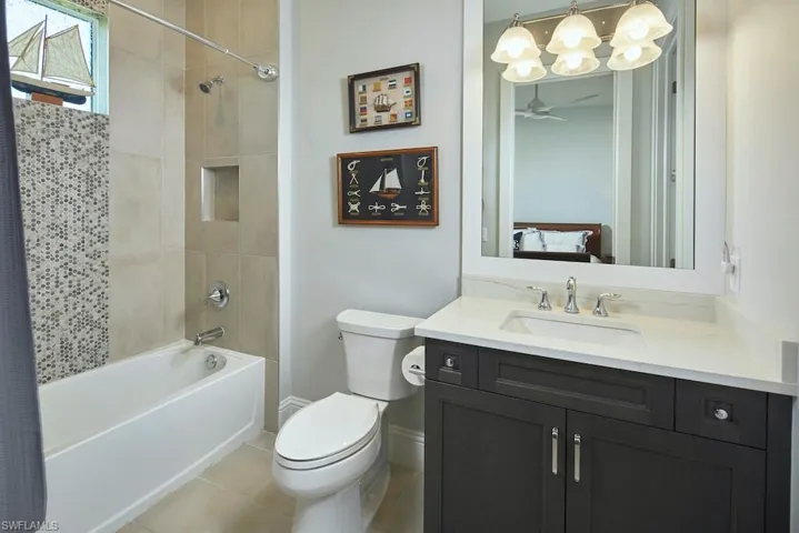 Full bathroom featuring vanity, shower / bath combo with shower curtain, toilet, and tile patterned floors