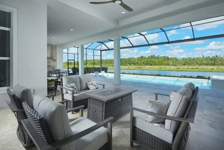 View of patio / terrace with ceiling fan, a water view, an outdoor living space, and a lanai