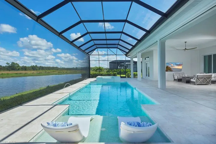 View of swimming pool with glass enclosure, a water view, an outdoor hangout area, ceiling fan, and a patio area