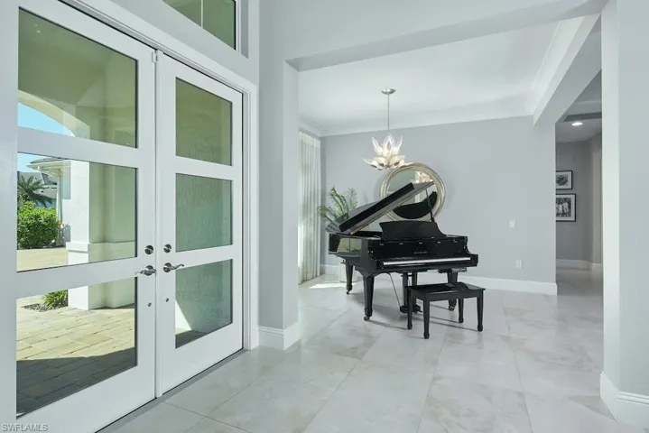 Miscellaneous room featuring a notable chandelier, ornamental molding, and french doors