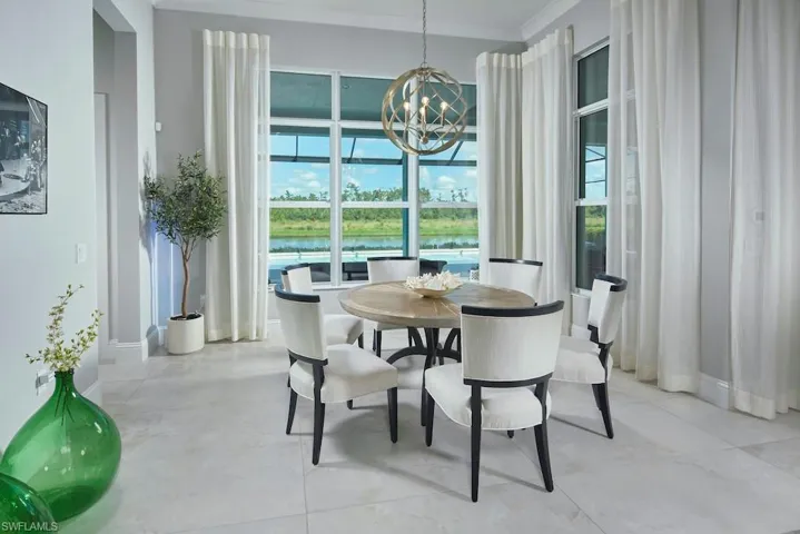 Dining space featuring crown molding, a water view, and an inviting chandelier