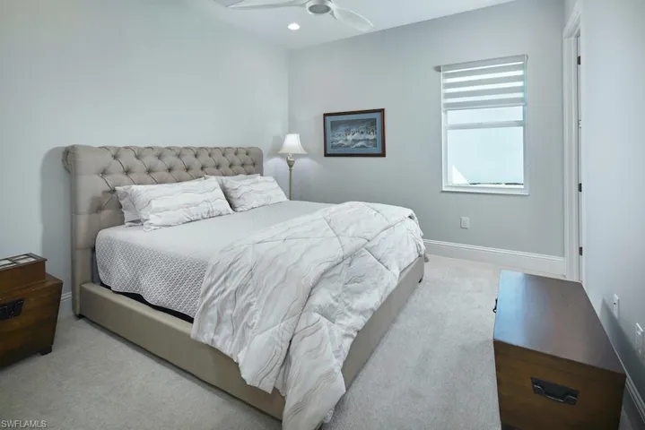 Bedroom with ceiling fan and light colored carpet