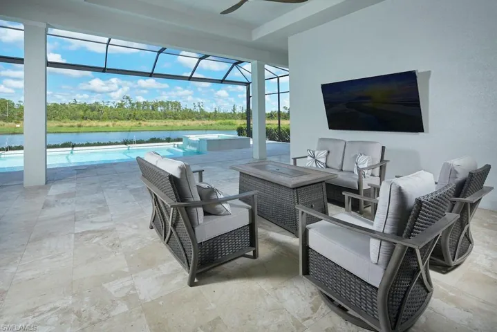 View of patio with glass enclosure, a water view, and an outdoor hangout area