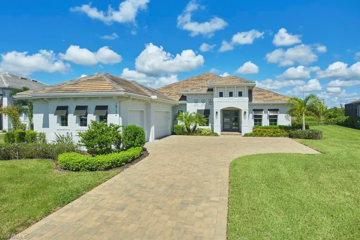 Mediterranean / spanish-style home with a front yard and a garage