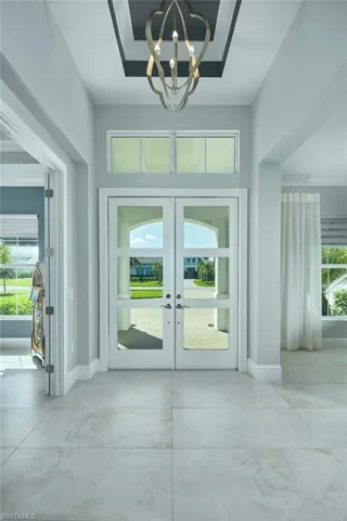 Entryway with a notable chandelier, concrete floors, and french doors
