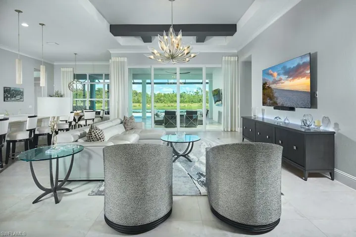 Tiled living room with ornamental molding and an inviting chandelier