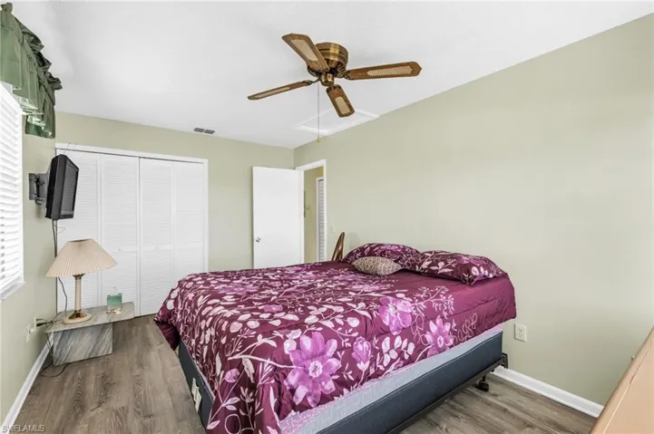 Bedroom featuring wood finished floors, a closet, and a ceiling fan
