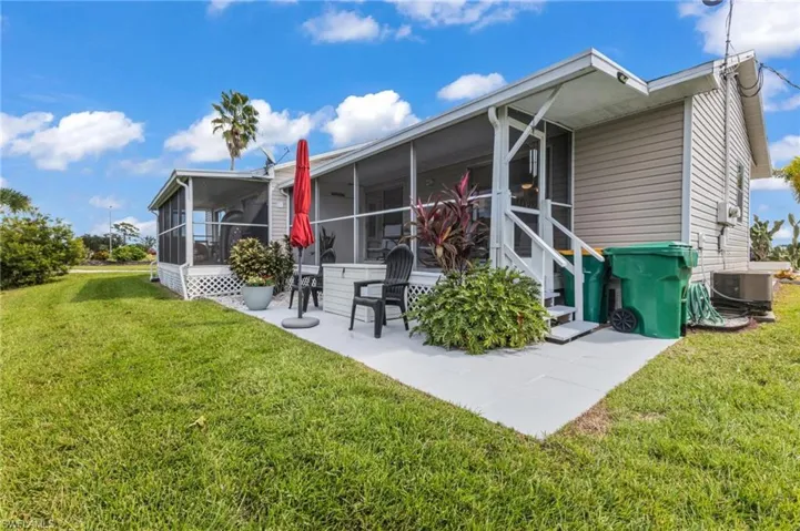 Back of house featuring a yard, a sunroom, and a patio area