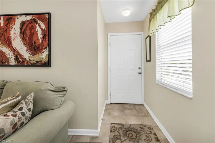 Doorway to outside featuring baseboards and tile patterned flooring