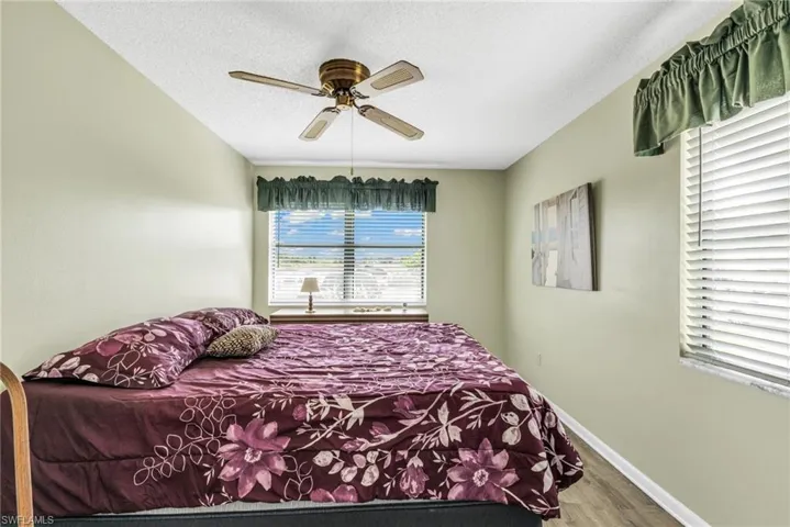 Bedroom featuring wood finished floors, ceiling fan, and a textured ceiling