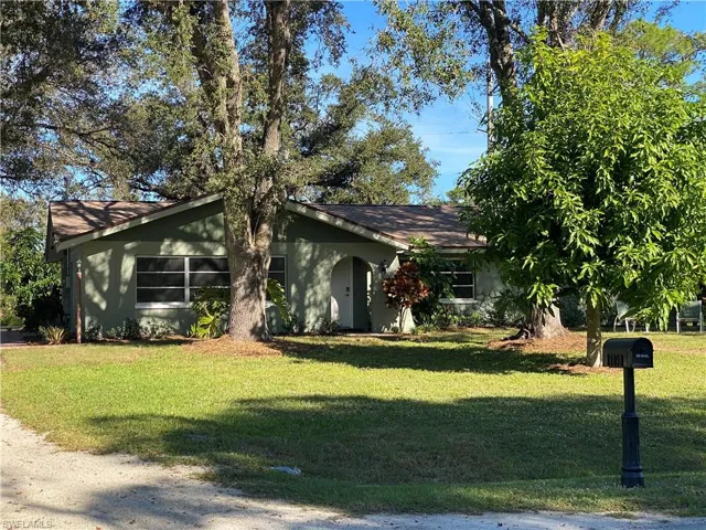 View of front of property with a front yard and stucco siding