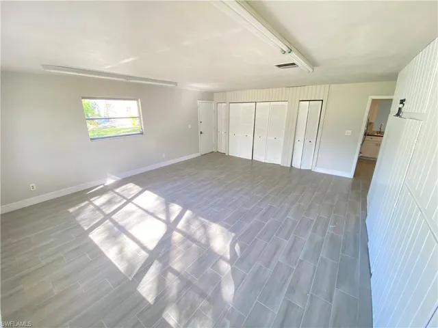 Unfurnished bedroom with two closets and wood finish floors