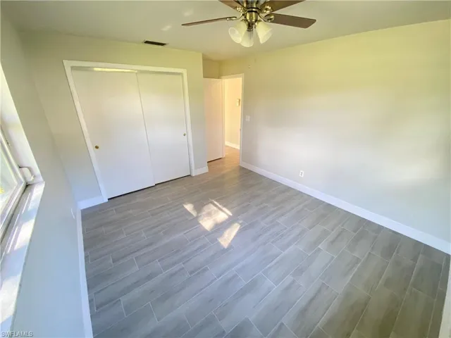 Unfurnished bedroom featuring a closet, a ceiling fan, and wood finish floors