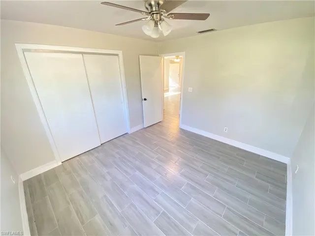 Unfurnished bedroom with wood finish floors, ceiling fan, and a closet