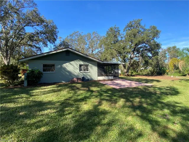 Rear view of property with a sunroom and a yard