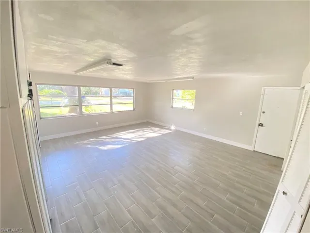 Unfurnished room with baseboards and wood finish floors
