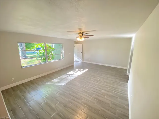 Unfurnished room with wood finish floors, a ceiling fan, and a textured ceiling