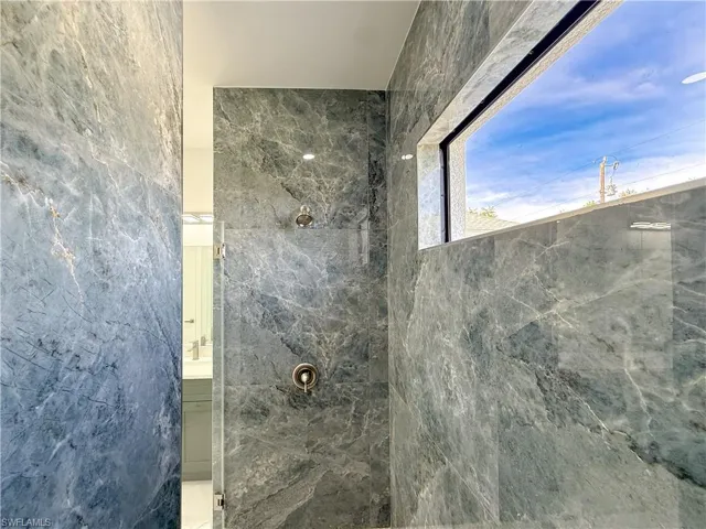 Full bathroom with a marble finish shower