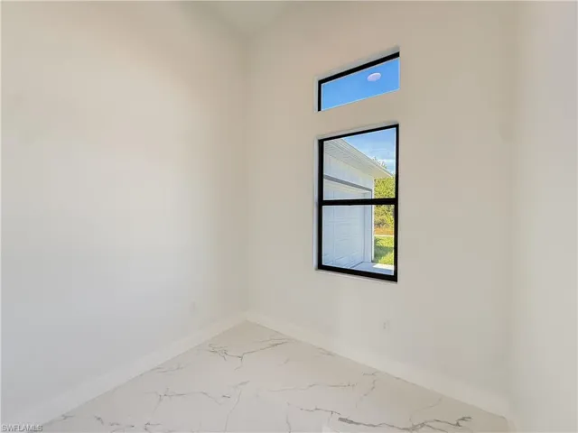 Unfurnished room with marble finish flooring and baseboards