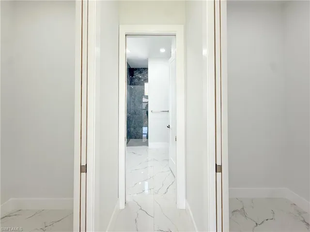 Hallway with light marble finish floors
