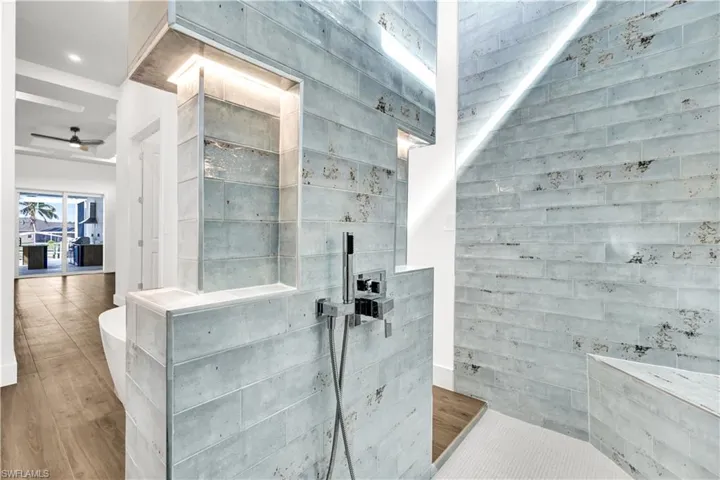 Bathroom featuring a ceiling fan, wood finished floors, and walk in shower