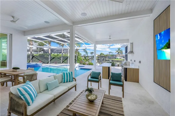 View of patio / terrace featuring ceiling fan, an outdoor hangout area, outdoor dining area, a pool with connected hot tub, and a lanai