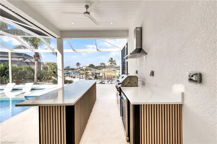 View of patio featuring a lanai, an outdoor pool, and ceiling fan