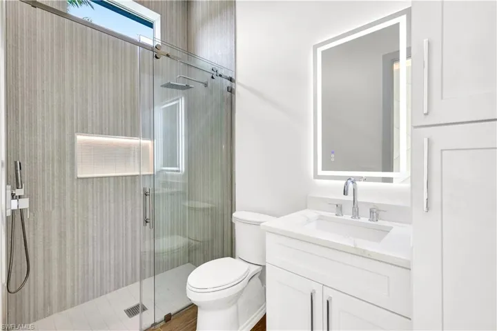 Bathroom featuring a shower stall, visible vents, toilet, and vanity