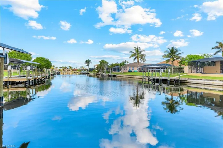 Water view featuring nearby suburban area, a dock, and boat lift