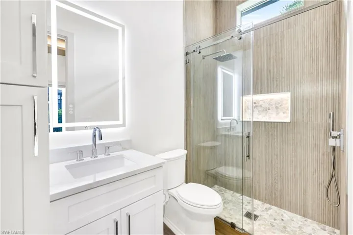 Bathroom with vanity, toilet, and a shower stall