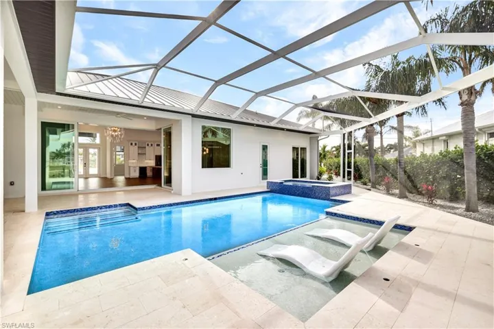 View of pool featuring a pool with connected hot tub, a lanai, and a patio area