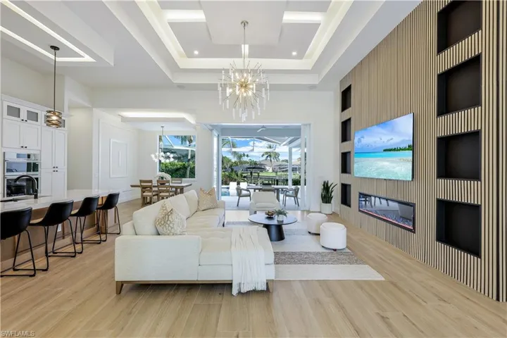 Living room featuring a chandelier, light wood finished floors, and a large fireplace