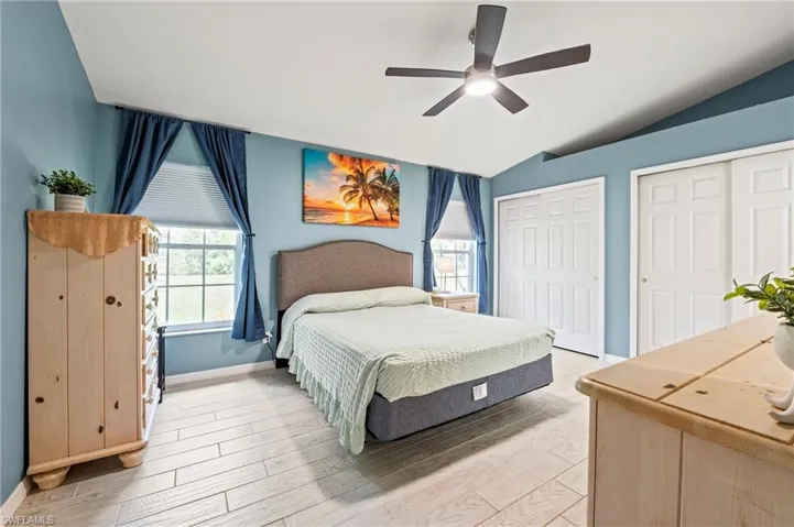 Bedroom featuring vaulted ceiling, light wood-type flooring, and ceiling fan