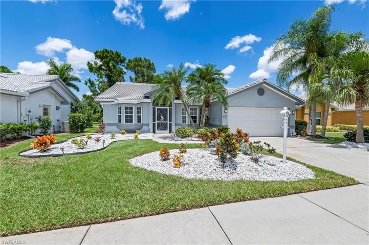 View of front of house featuring a garage, central AC unit, and a front yard