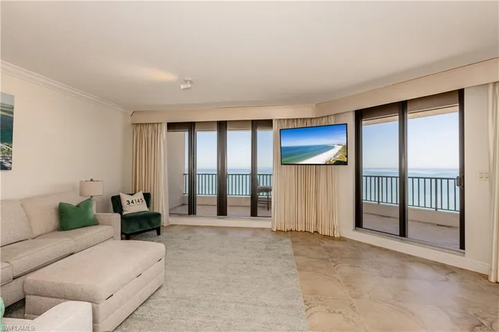 Living room featuring crown molding and plenty of natural light