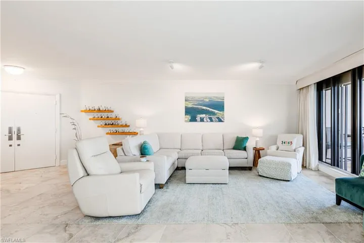 Living room featuring light tile patterned flooring, crown molding, and a healthy amount of sunlight