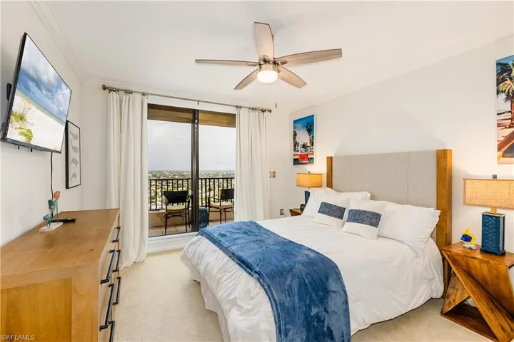 Carpeted bedroom with ceiling fan, crown molding, and access to exterior