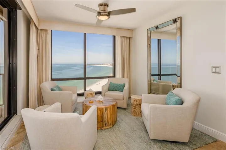 Sitting room featuring light tile patterned flooring, a water view, and ceiling fan